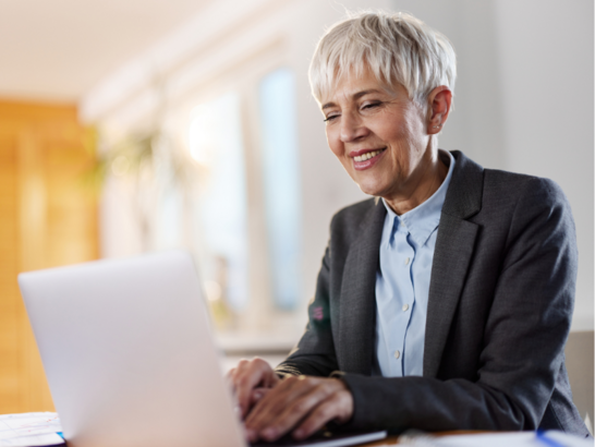 Lachende Frau vor einem Laptop