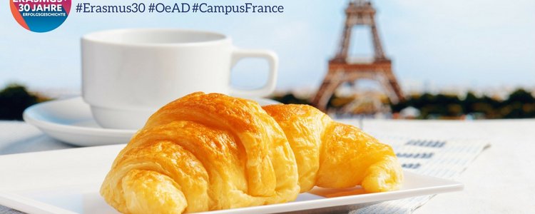 Bild zeigt im Vordergrund ein Croissant, dahinter eine Tasse und dahinter den Eiffelturm