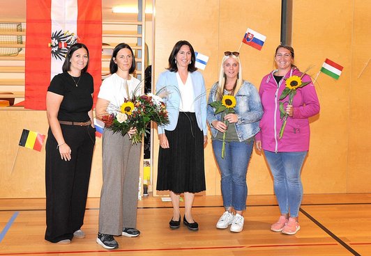 Die Schulleiterin überreicht mit einer Kollegin Blumesträuße an zwei Vertreterinnen des Elternvereins