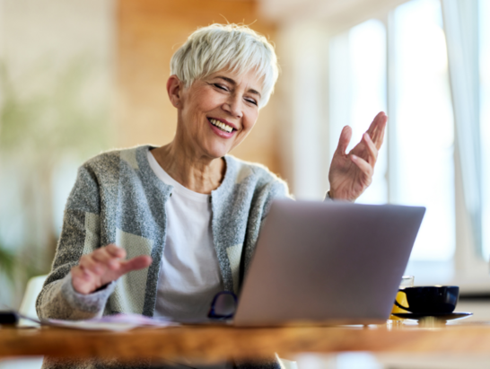 Lachende Frau vor einem Laptop